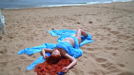 Frau-Mit-Roten-Haaren,-Die-Sich-Am-Strand-Ausruht.-Nahaufnahme-Einer-Schwangeren-Frau,-Die-Am-Meeresstrand-Liegt