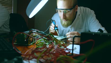 Robotic-engineer-assembling-circuit-board-at-desk-4k