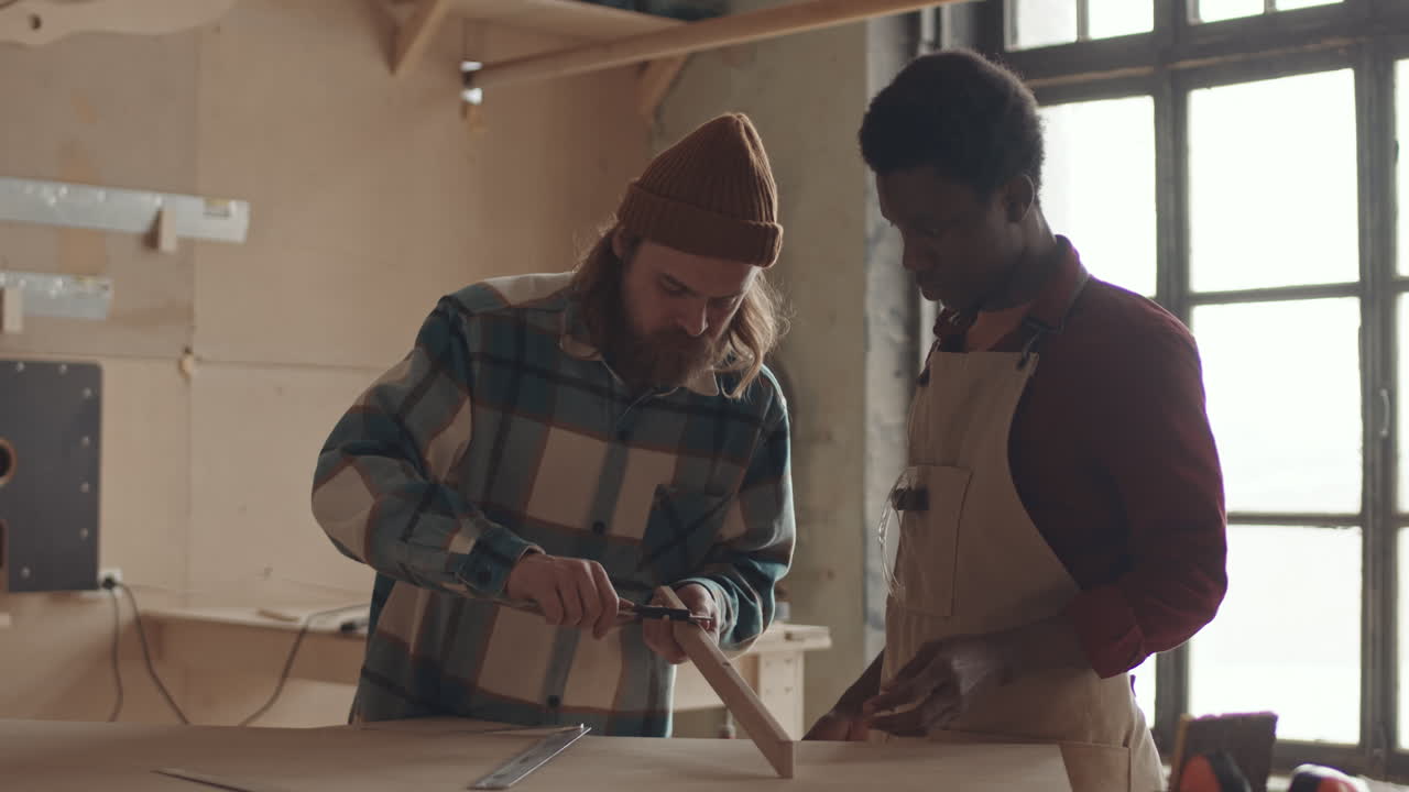 African American Man Watching Professional Joiner Working with Wood