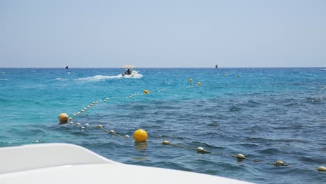 Vista-Desde-Un-Barco,-Viendo-Una-Carrera-De-Lanchas-Rápidas-A-Través-Del-Hermoso-Mar-Azul