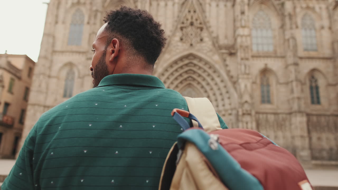 Uomo con zaino di fronte a una cattedrale