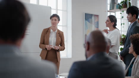 young business woman team leader presenting project strategy showing ideas on whiteboard in office presentation diverse colleagues enjoying training seminar