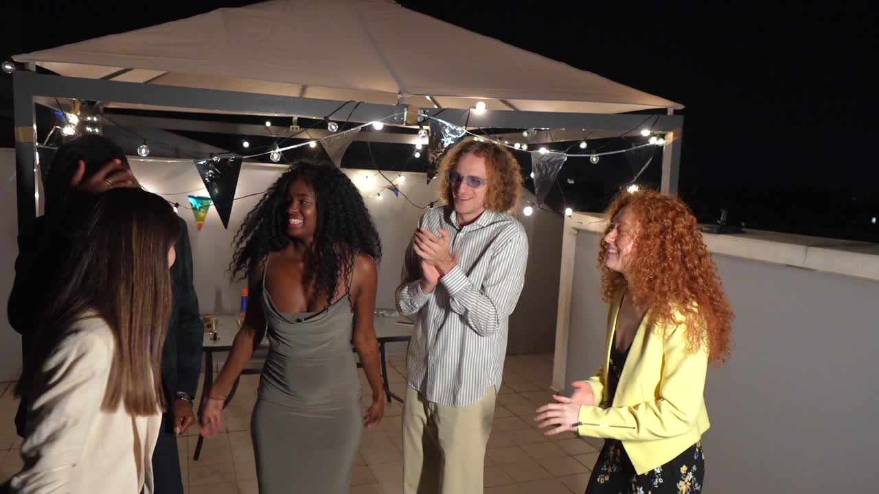 Group of friends celebrating with a hug at night