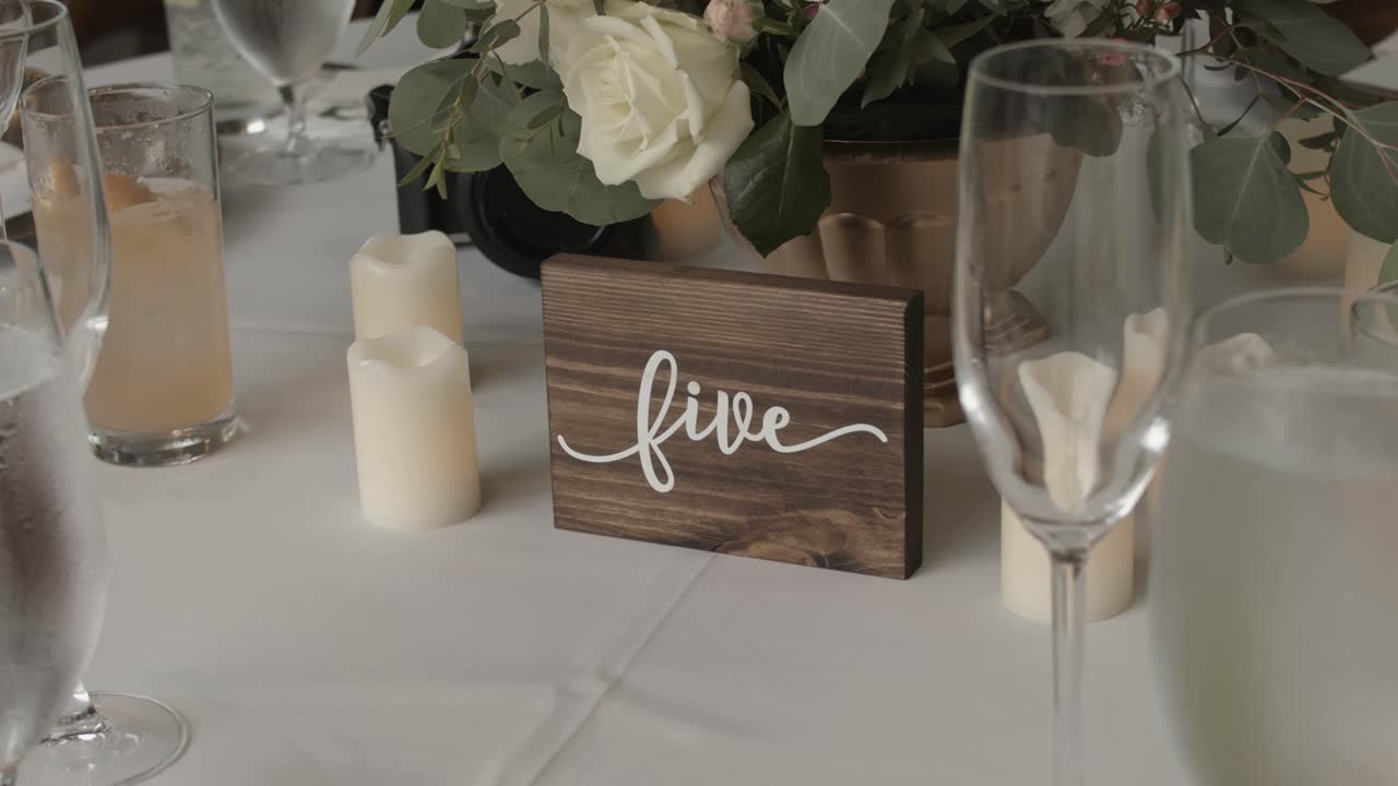 Cena nuziale con vista su decorazioni in legno circondate da candele, fiori e calici alti