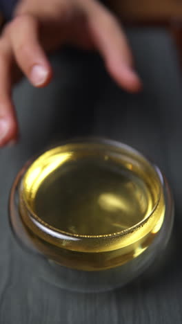 glass teacup of yellow tea