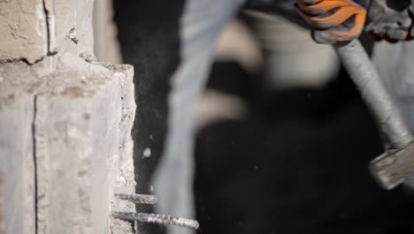 sledgehammer striking concrete wall, dust and debris flying, close up slomo