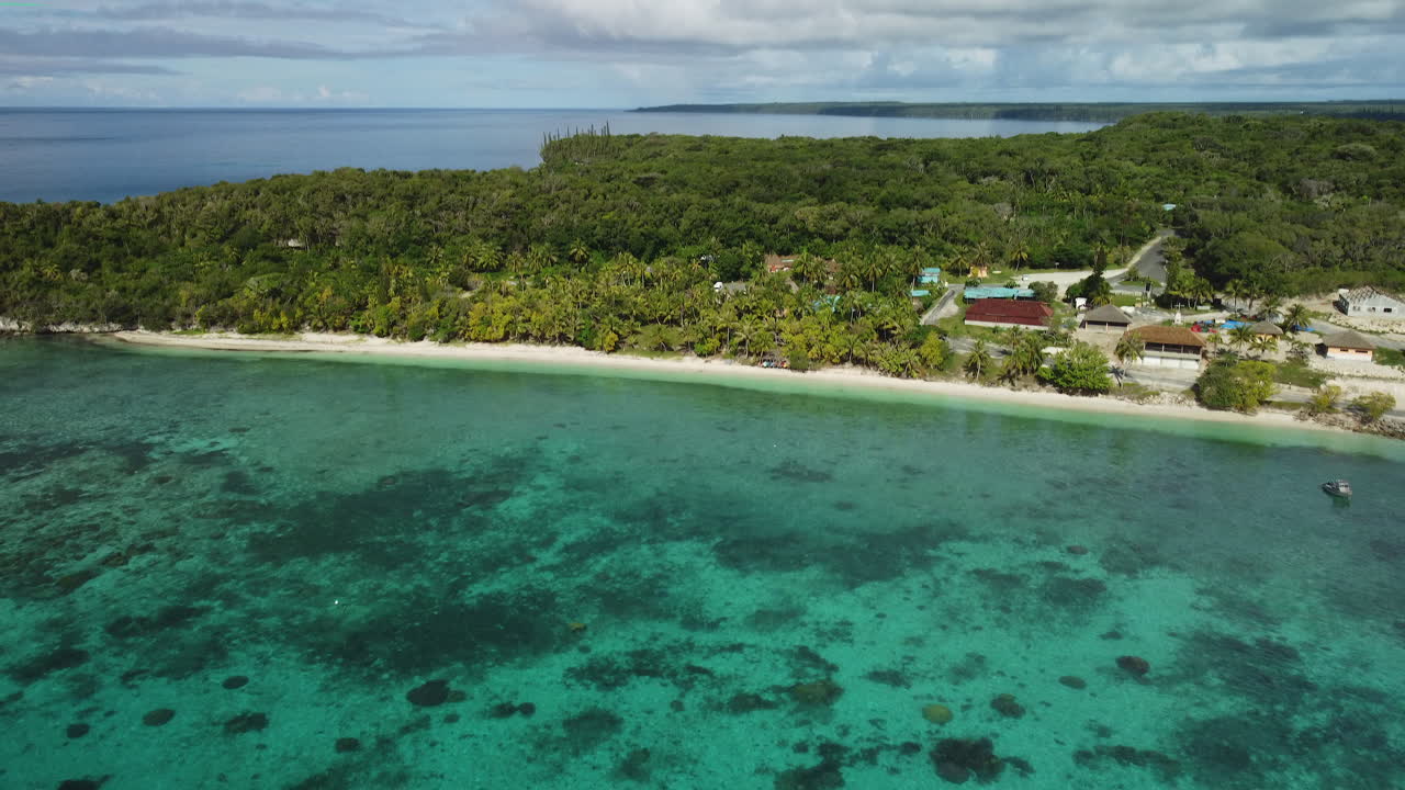 Ripresa aerea in allontanamento da un piccolo villaggio sull'isola di Lifou, Nuova Caledonia