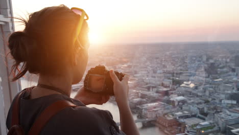 Tourist-taking-photograph-of-sunset-in-london-skyline--view-from-The-Shard