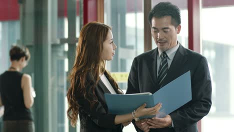 asian businessman talking to assistant in company lobby