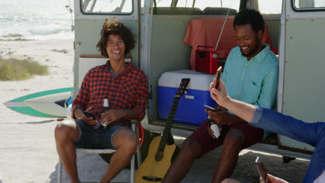 young friends sitting together near camper van 4k