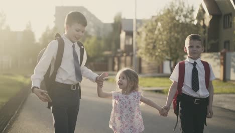 cu tracking slow motion young schoolchildren who have school bags behind them