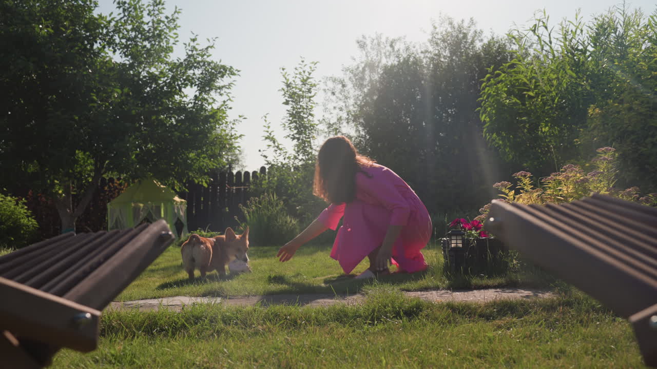 Woman Sitting Peacefully With Pet Outdoors, Serene Woman Relaxing With Her Dog In Garden, Tranquil Image Of Woman In Pink Dress Seated With Her Dog Outside During Peaceful Garden Afternoon