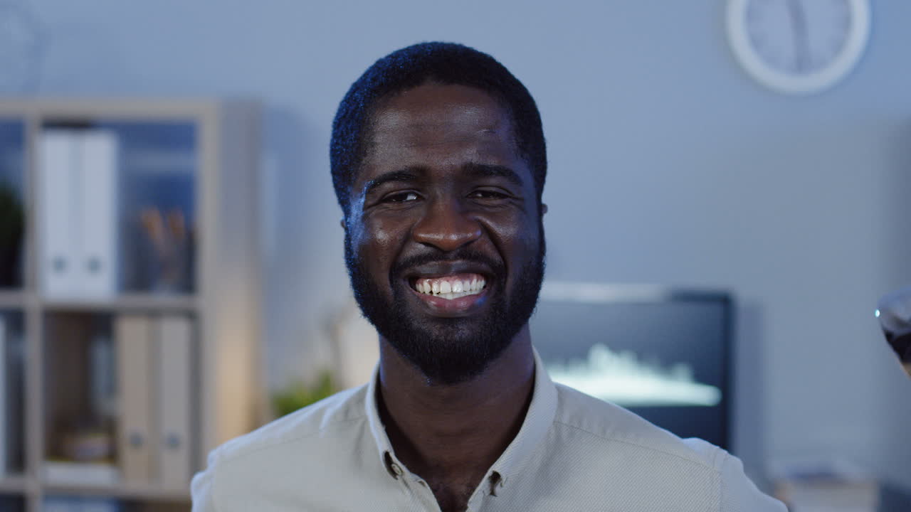 Close Up View Of Office Worker Smiling Cheerfully To The Camera In The Office At Night