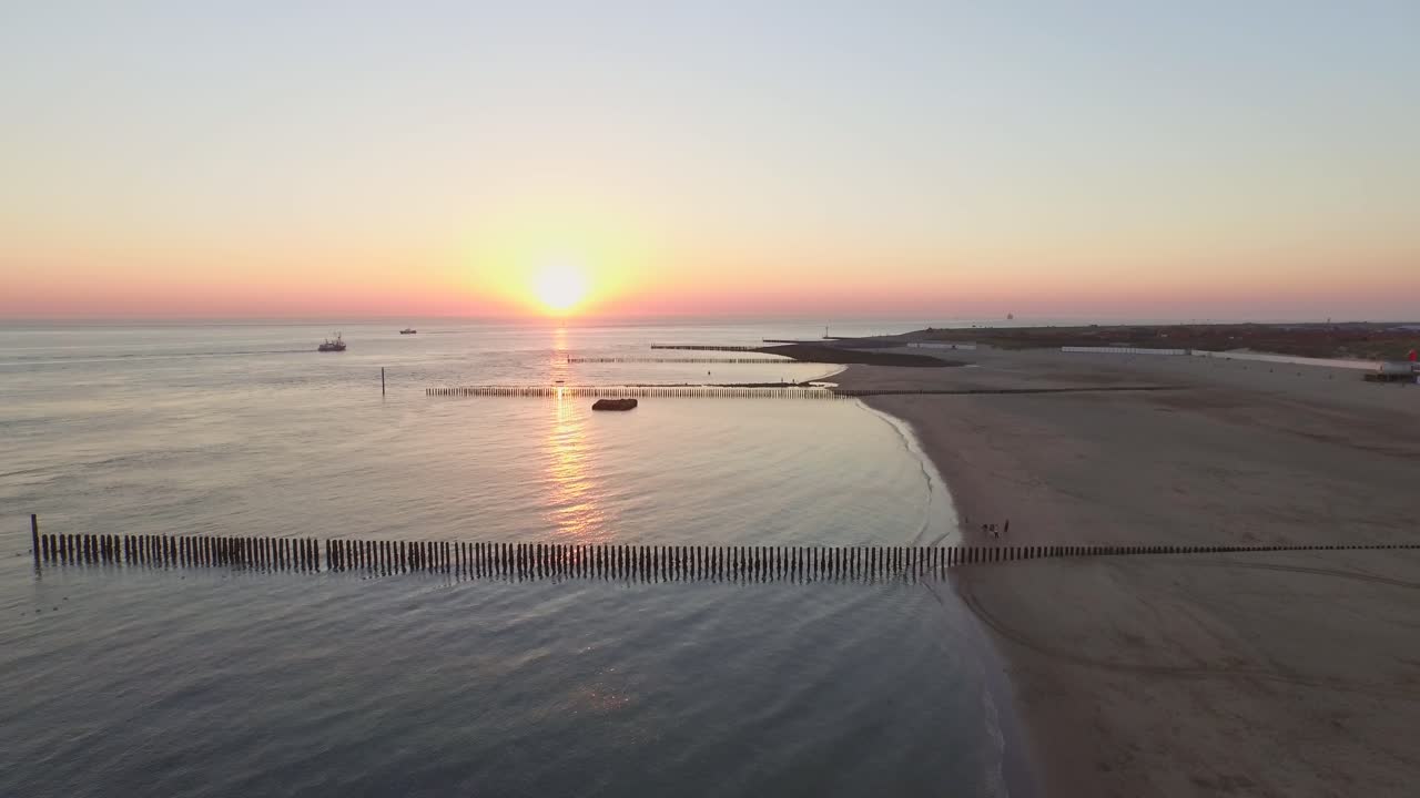 Vista aerea: Il molo, la spiaggia e il faro al tramonto vicino al villaggio di Westkapelle, Paesi Bassi