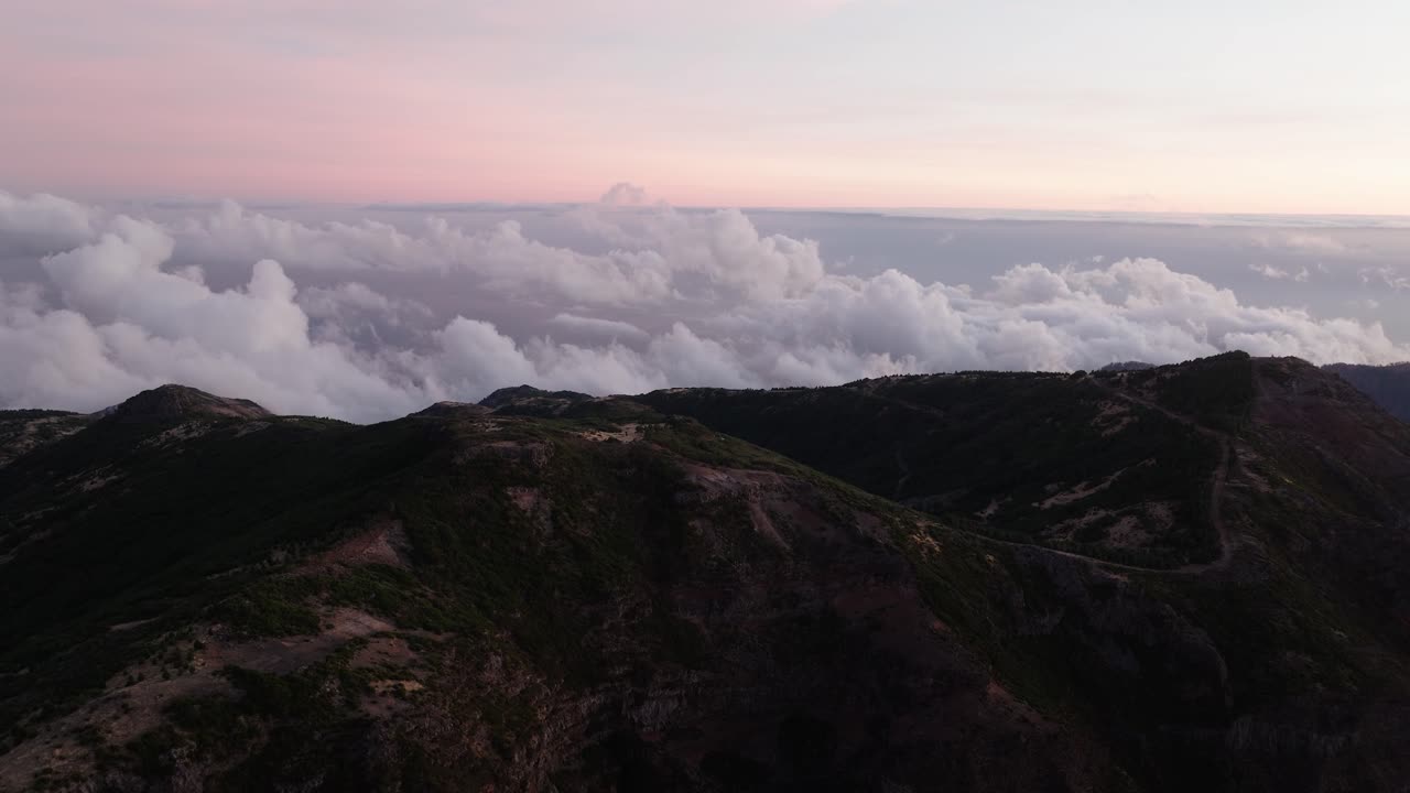 Delicate morning light paints Pico do Arieiro’s ridgelines as a wall of clouds stretches across the horizon beneath a pastel sky.