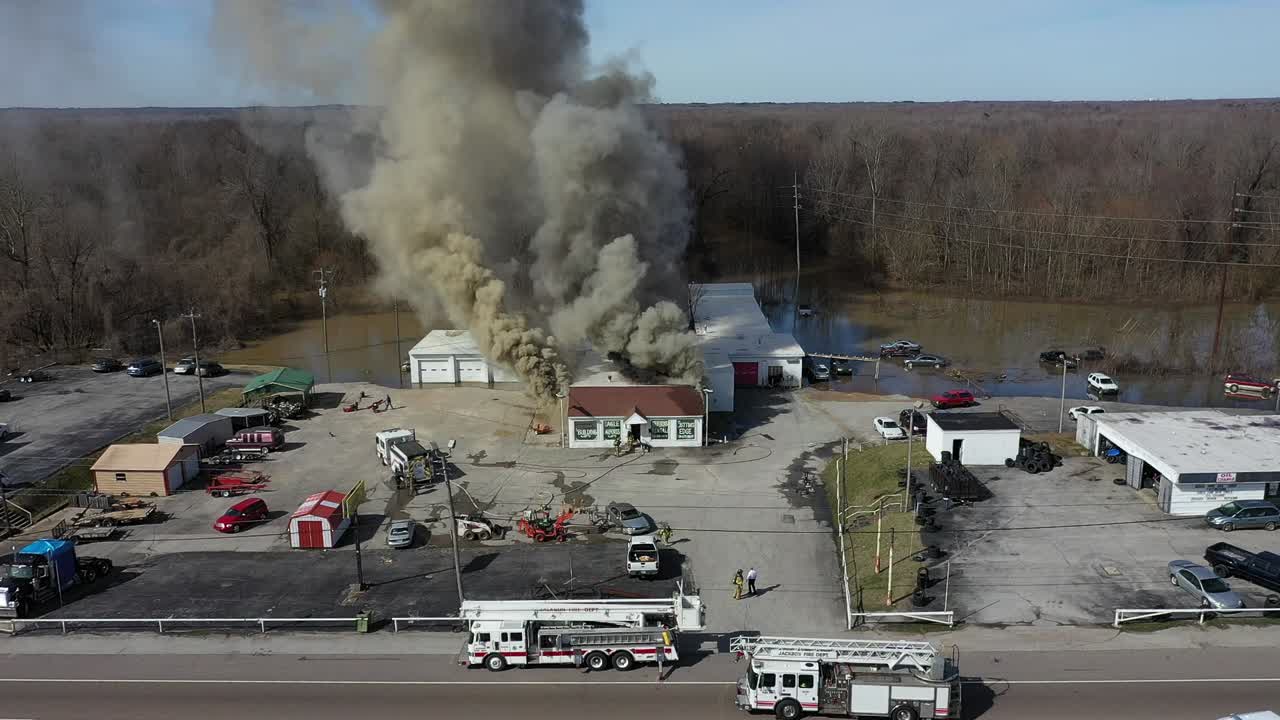 Drone view pulling back to reveal more of an active fire with multiple agencies in attendance including local fire and police