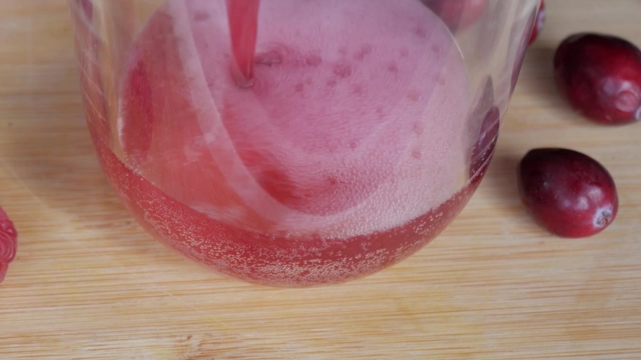 Bicchiere vuoto con frutti di bosco su tavolo di legno, atmosfera pronta per preparare un milkshake.