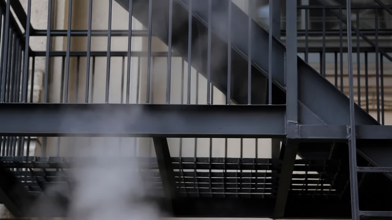 Steam Rising from Below a Dark Metal Fire Escape