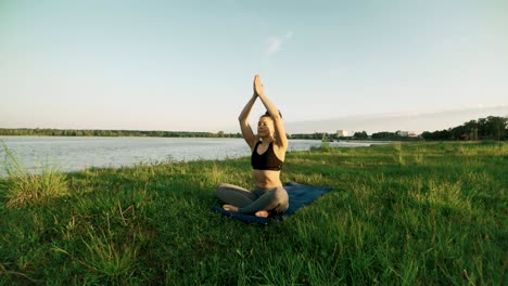 beautiful woman practicing yoga in morning. girl doing yoga moves on green grass