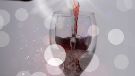 Animation-Von-Rotwein,-Der-Auf-Einem-Hintergrund-Mit-Lichtern-In-Ein-Glas-Gegossen-Wird