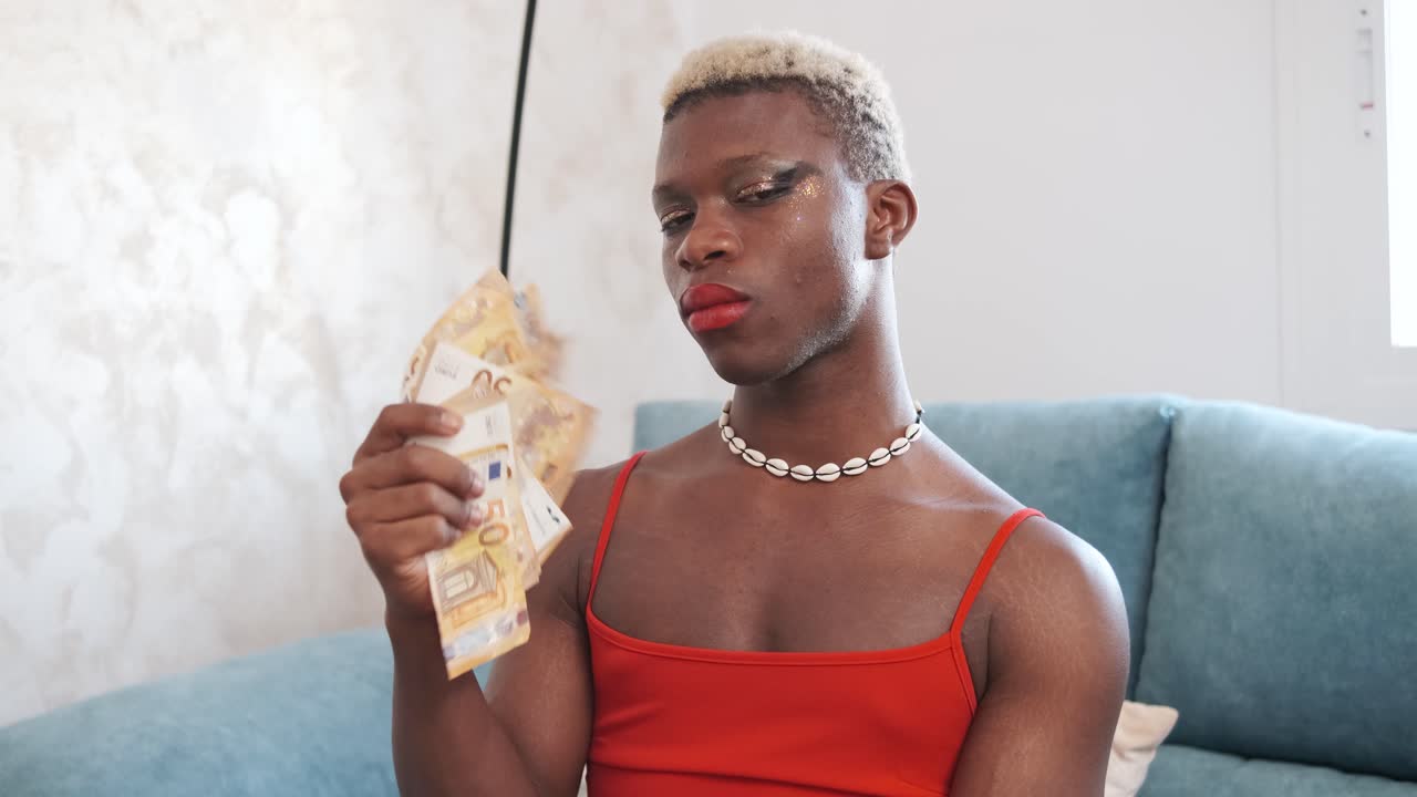 Person with makeup and blonde hair holding Euro banknotes