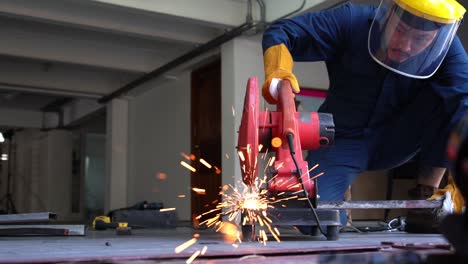 Professional-mechanic-is-cutting-steel-metal.