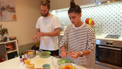 couple cooking dinner at home with baby