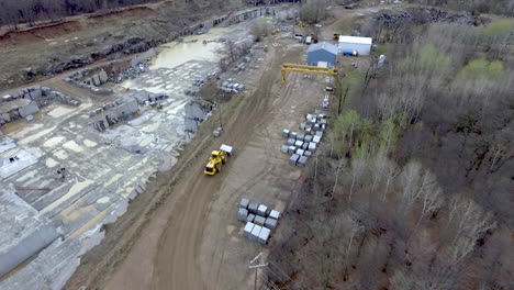 Front-Loader-Construction-Vehicle-Moving-Massive-Block-of-Granite-in-Quarry