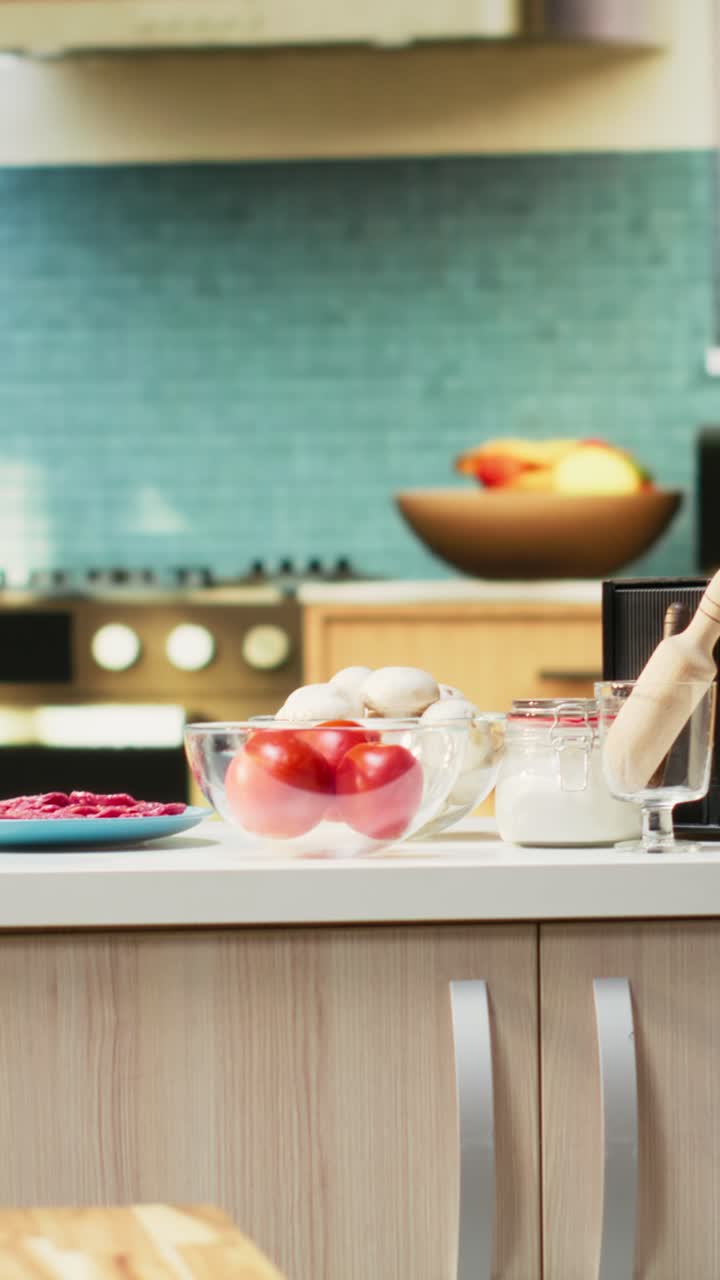Vertical Video Modern kitchen filled with fresh pizza ingredients on the countertop