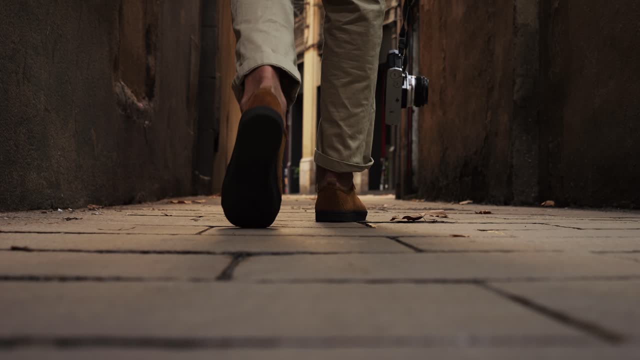Legs with boots of walking Happy tourist man in Barcelona, Spain. Vacation exploring interesting places to travel, student vacation, young man portrait walking in gothic square, old european city