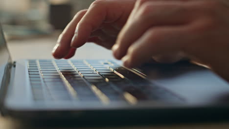 man hands typing laptop keyboard searching internet in office desk close up.