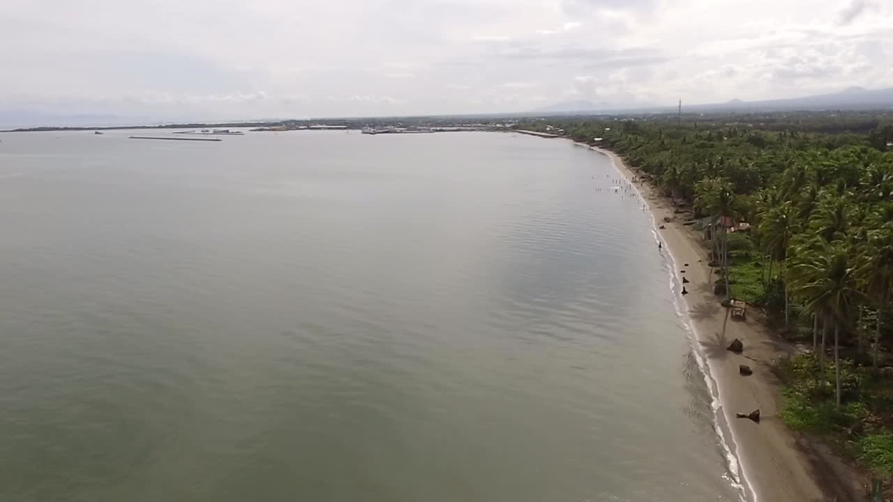 playa de arena vacía y hermoso mar tranquilo en un día nublado, drone aéreo