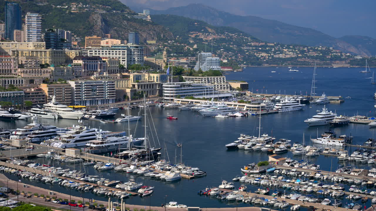 View of boats docked in the Monaco Marina with the skyline of the city on the background