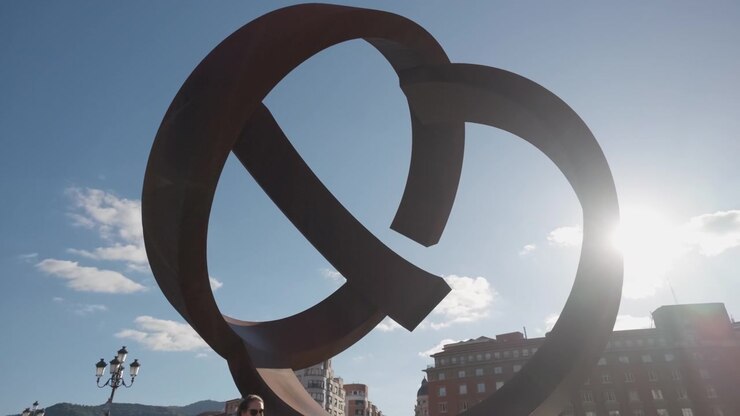 Abstract steel sculpture La Salve Bridge creating an iconic landmark on a clear blue sky, representing Bilbao architecture and art