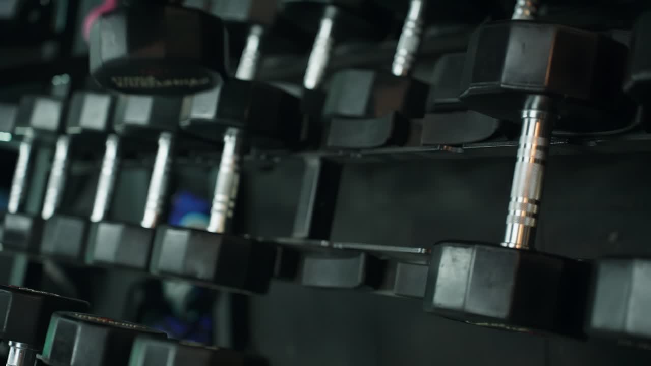 Man's hands close-up picking up dumbbells