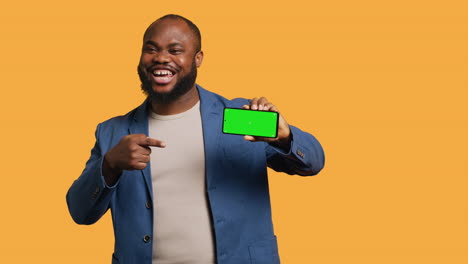 portrait of man doing influencer marketing using green screen phone