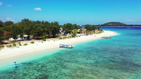 Island-In-Samoa---Boats-Docked-On-The-Sandy-Shore-Of-A-Lush-Island-Surrounded-By-Clear-Blue-Ocean-Water-With-Coral-Reef-At-The-Bottom---Aerial-Shot