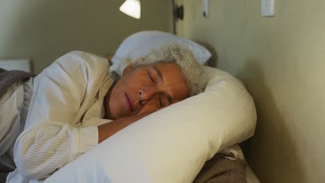 Senior-mixed-race-woman-lying-in-bed-sleeping