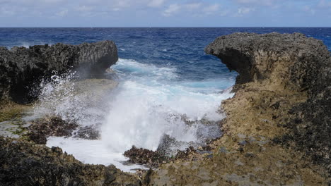 powerful waves crashing against rocks on pacific coastline, slow motion