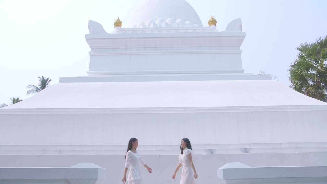 Two Asian Girls Holding Hand And Having Fun On Summer Travel Near The Temple, Slow Motion