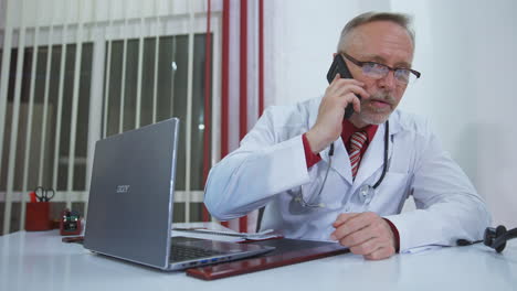 doctor talking on mobile phone. mature doctor talking with patient on mobile phone