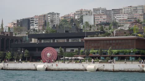 a view of the city of istanbul, turkey, with buildings, people, and water in the foreground.