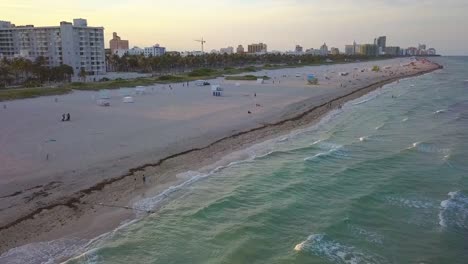 vista aérea con vistas a la gente en la playa de south point, puesta de sol en miami, estados unidos