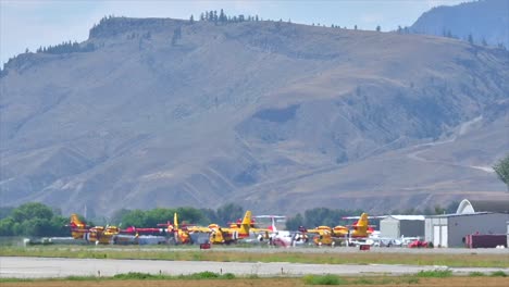 una flota de aviones de extinción de incendios espera en el aeropuerto de kamloops cubierto de humo