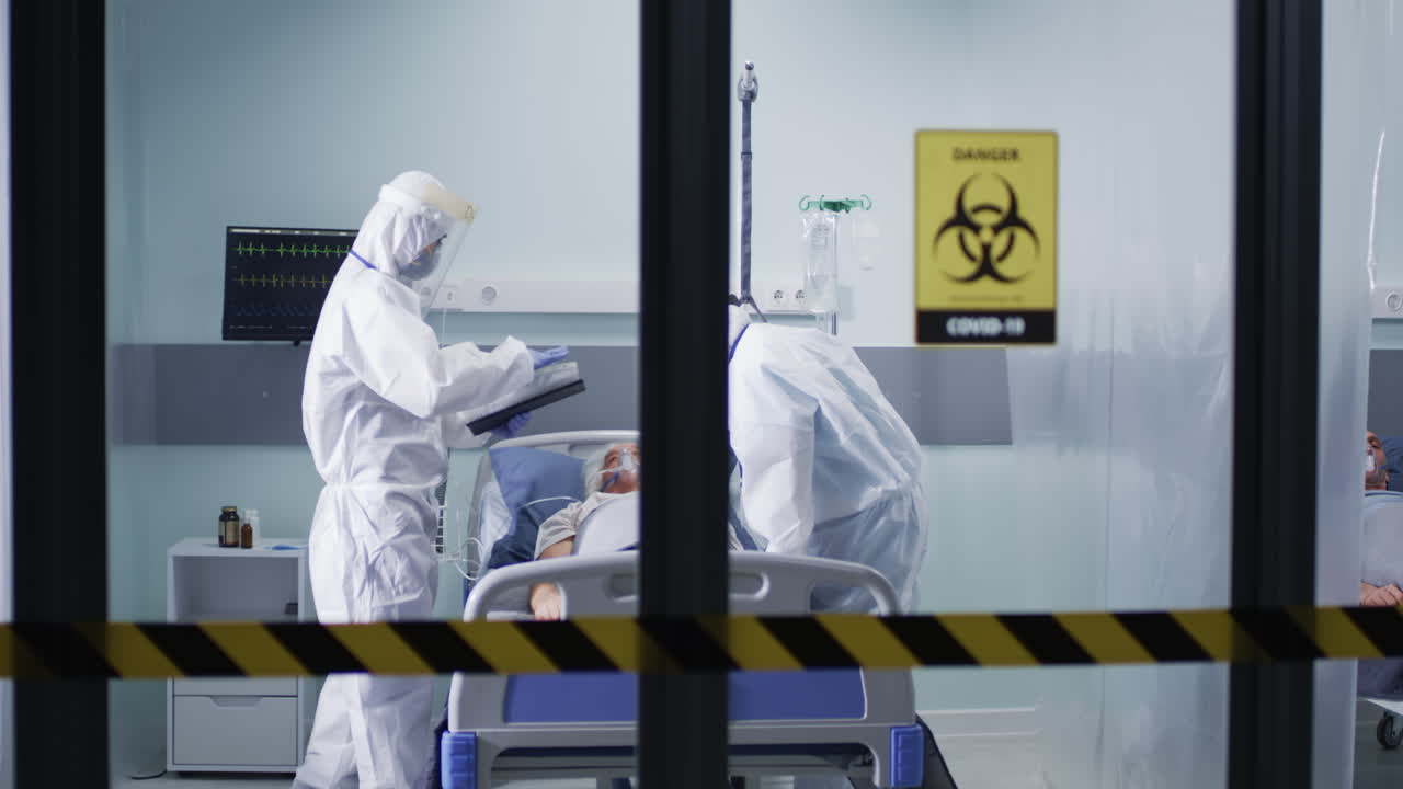 Healthcare Workers in PPE Attend to COVID-19 Patients in Hospital ICU