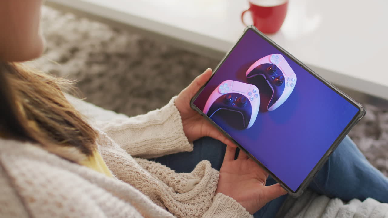 mujer caucásica usando tableta en casa para comprar en línea, controladores de juegos en pantalla, cámara lenta