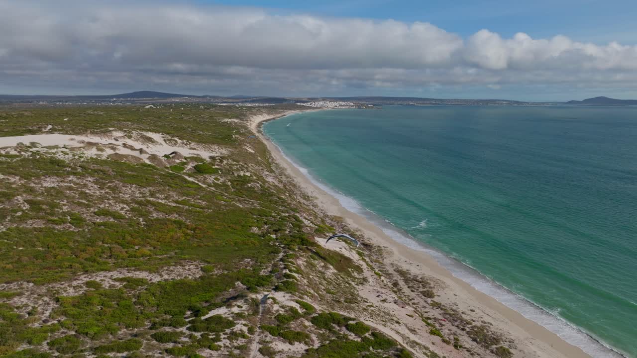 Paraglider soars above the scenic coastline of Langebaan in Western Cape, South Africa