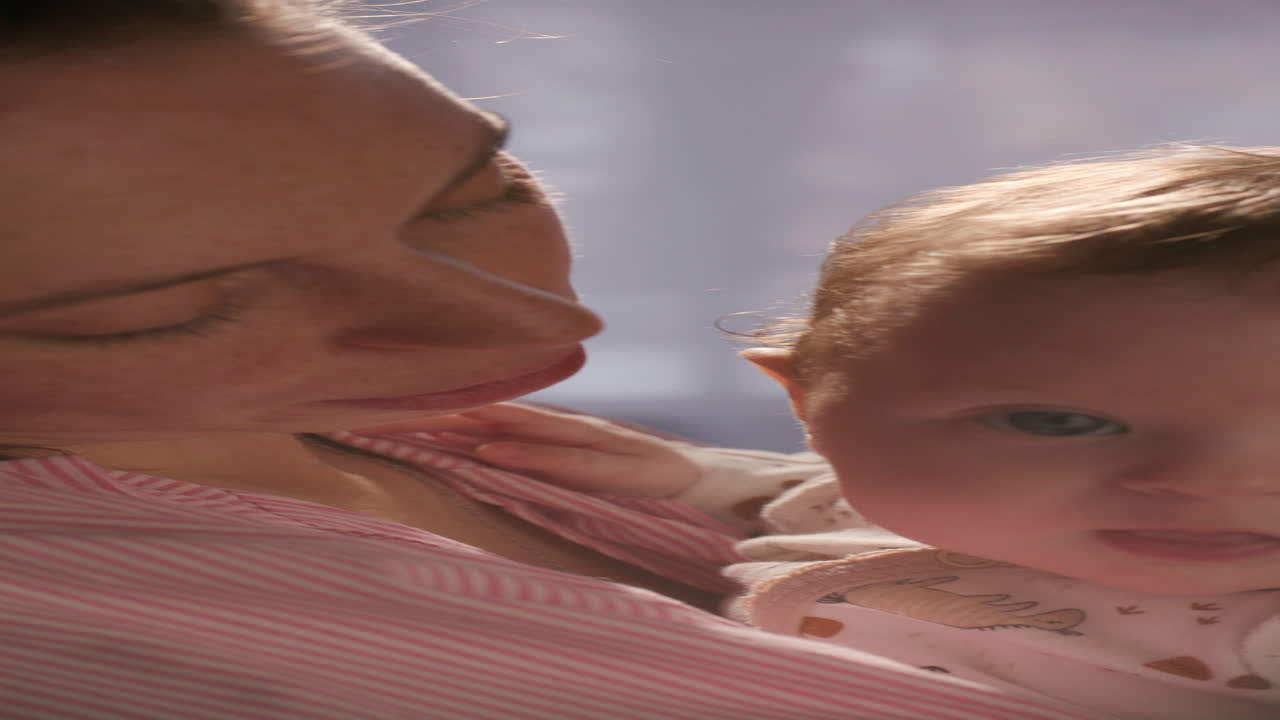 Nahaufnahme einer Mutter, die ihr bezauberndes Baby hält und sanft küsst