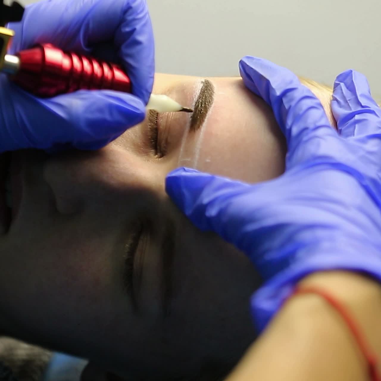 tatuador haciendo maquillaje permanente