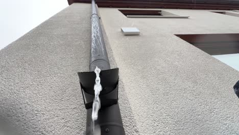 looking up at a rain pipe during rainy weather